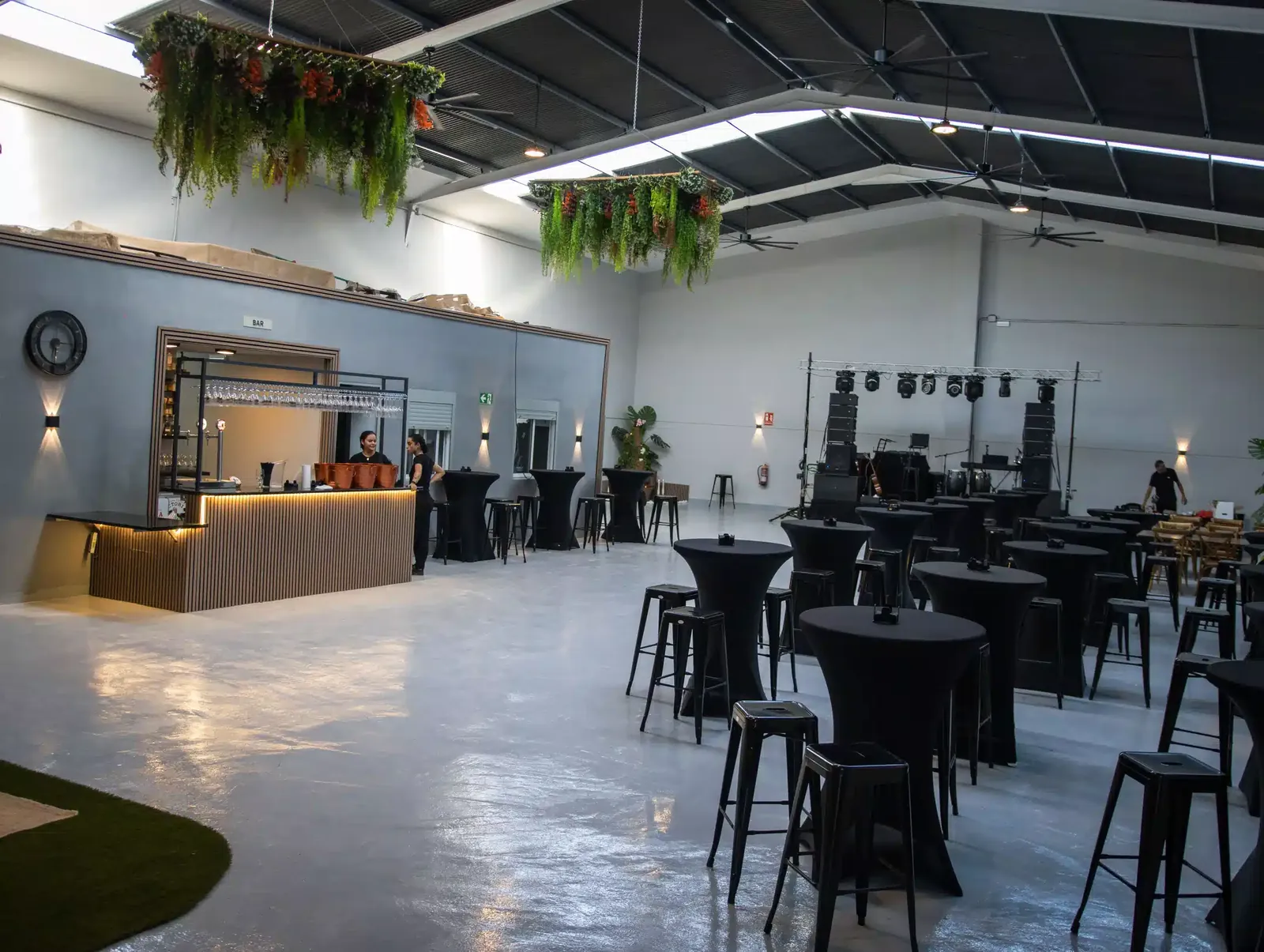 Vista general del salón de eventos LA NAVE 77 en Málaga con la barra a la izquierda y el escenario al fondo